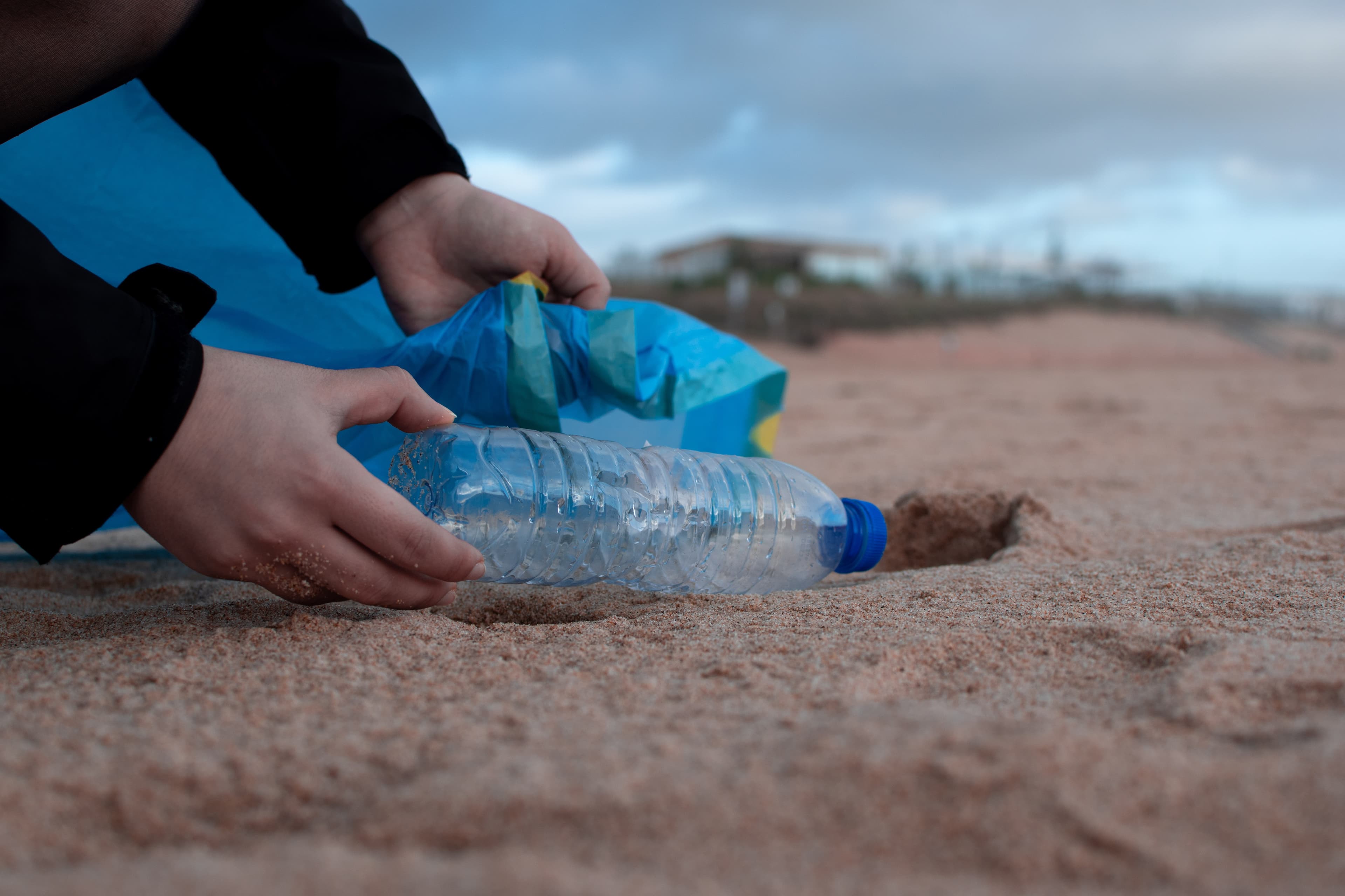 Picture of a plastic bottle being collected from the beach